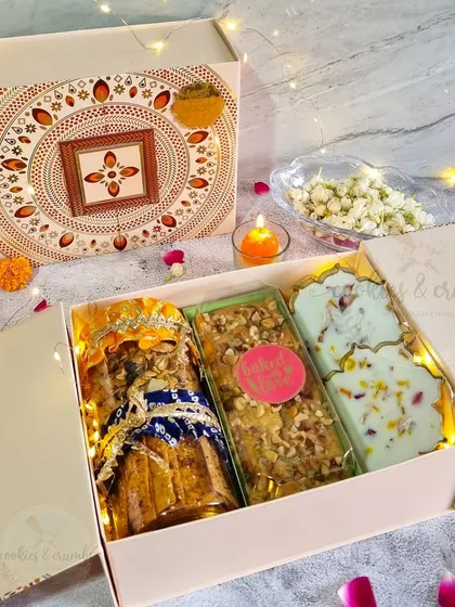 A beautiful Diwali hamper featuring a mix of my treats. This box includes a jar of cookies, a nutty tea cake, and white chocolate mendiants in a festive box.