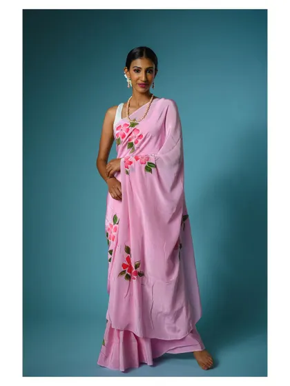 A full-length shot of a model in a modern, draped saree. The pose is elegant and showcases the unique design of the garment.