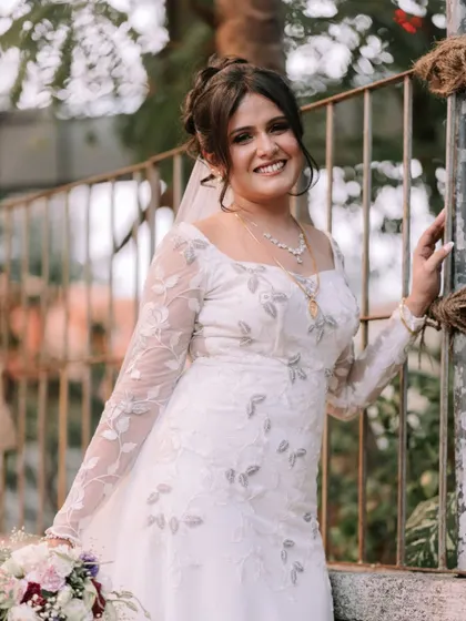Posing by a rustic gate, this bride looks effortlessly beautiful. Her classic updo and natural makeup are perfect for the outdoor setting.