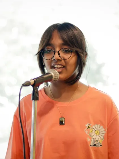 A young vocalist sharing her talent at a student recital. These performances are a huge confidence booster.