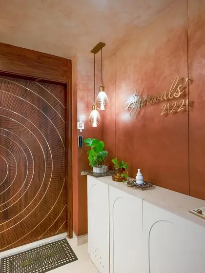 The entryway of a contemporary home, featuring a custom door with concentric brass inlay and a sleek white console. This sets a modern and artistic tone from the moment you enter.