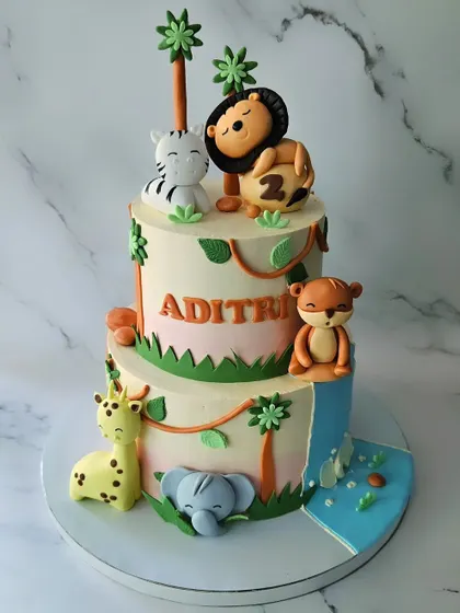 A jungle cake with a twist! This two-tier vanilla and strawberry cake features a waterfall element and adorable sleeping and climbing fondant animals for Aditri's second birthday.