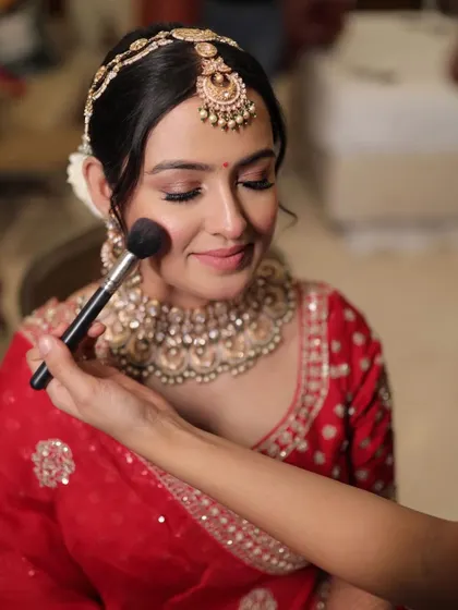 The final touch of blush for bride Krusha. This moment captures the care and detail that goes into perfecting every bridal look.