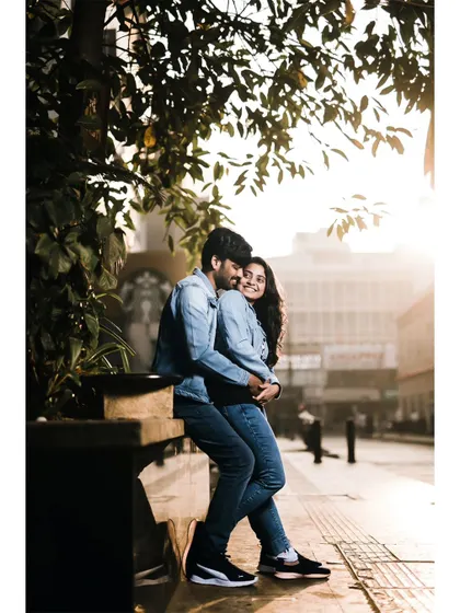 A romantic embrace on a city bench, with the morning sun creating a warm and beautiful glow around the couple.