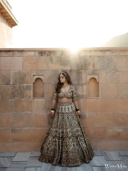 The bride standing against a stone wall with the sun creating a beautiful flare behind her. This is a modern yet timeless bridal portrait.