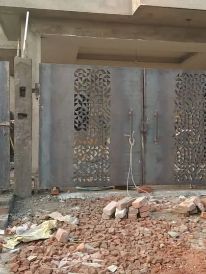 A custom MS gate with a CNC-cut pattern being installed on site. This is an example of bringing modern fabrication techniques into exterior design.