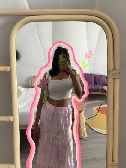 A mirror selfie showing off a cute outfit, with a pink outline and a tulip doodle for a girly touch.