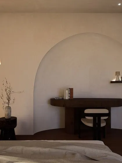 A signature arch creates a cozy nook for a study desk within the bedroom. This architectural detail adds softness and character while defining a functional zone within the serene space.