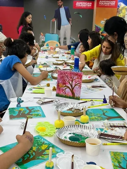 A table full of families painting together at our 'Palette Harmony' workshop. These events are designed to be a shared experience, where parents and children can learn and create side-by-side.