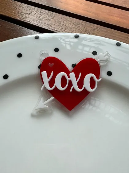 A cute "xoxo" charm with a heart and arrow. This layered acrylic piece is a fun and modern take on Valentine's decor.
