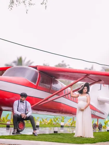 A wider shot of the airplane prop, showing the full scale of the setup. The expecting mother stands proudly by the plane, creating a powerful and memorable image from her pregnancy photoshoot.