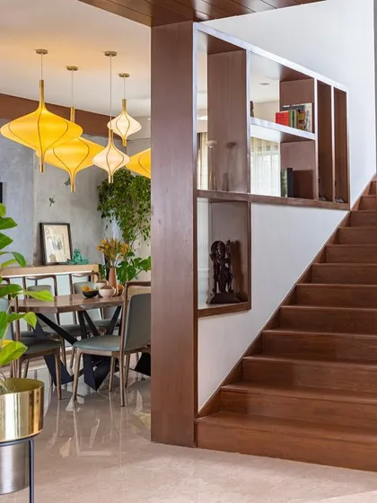The dining area is visible from the staircase, which features built-in shelving for display and storage. This integration of furniture and architecture is a key part of how we maximize functionality in our designs.
