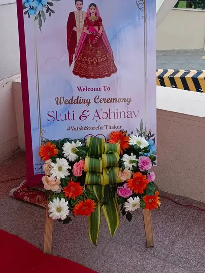 I also provide custom welcome signs with floral arrangements. This easel stand features a personalized wedding welcome board, beautifully decorated with a fresh arrangement of gerberas and roses.