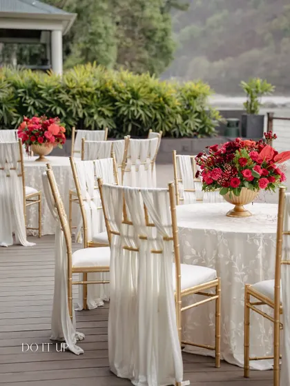 Elegant guest seating for a riverside ceremony in Rishikesh. The classic chairs are adorned with simple, flowing drapes, adding a touch of softness that complements the natural setting.