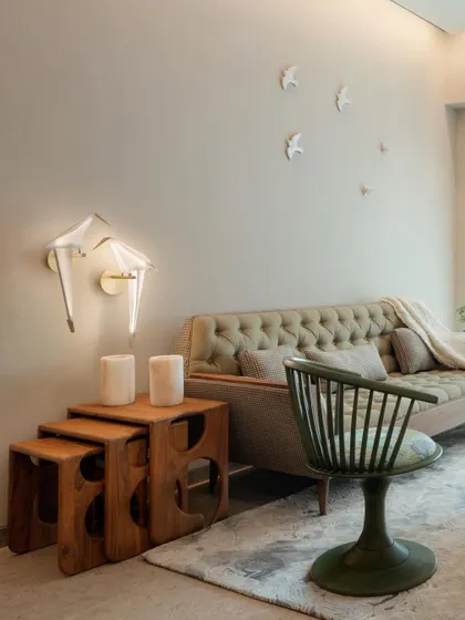 An eclectic living room corner with unique furniture pieces, including a green spindle chair and nested wooden tables, showcasing our flair for curated design.