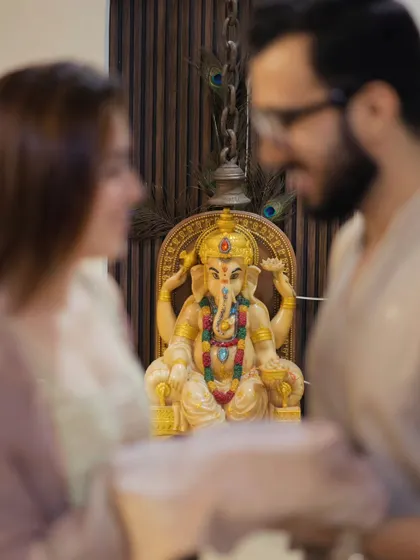 Seeking blessings for the journey ahead. Incorporating spiritual or cultural elements, like this moment with a Ganesha idol, adds a deep layer of meaning to your pre-wedding story.