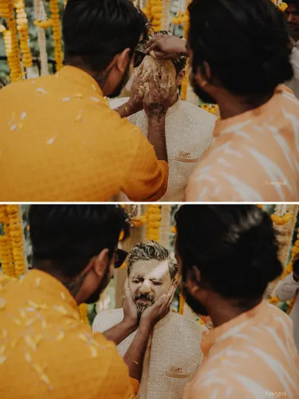 The groom gets his share of the Haldi fun, as his friends playfully apply turmeric paste to his face.