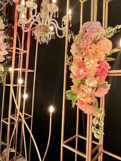This reception stage was designed for a live band performance. I used an elegant framework with chandeliers and floral arrangements against a black backdrop for a dramatic and stylish effect.