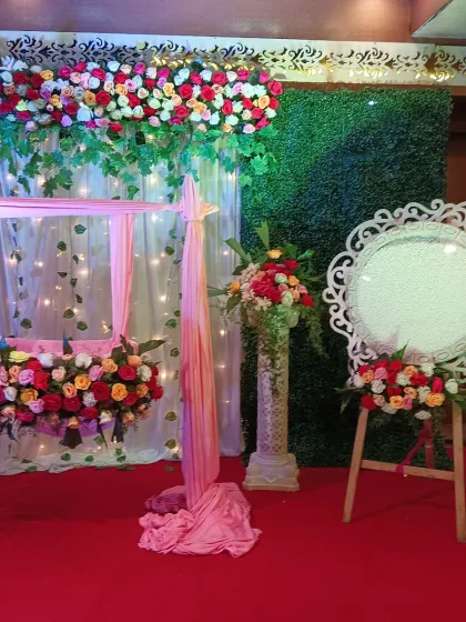 For this naming ceremony, we created a beautiful setup featuring a decorated floral swing, or jhoola. The backdrop combines a green wall with light drapes and fairy lights, making it a perfect spot for photos.