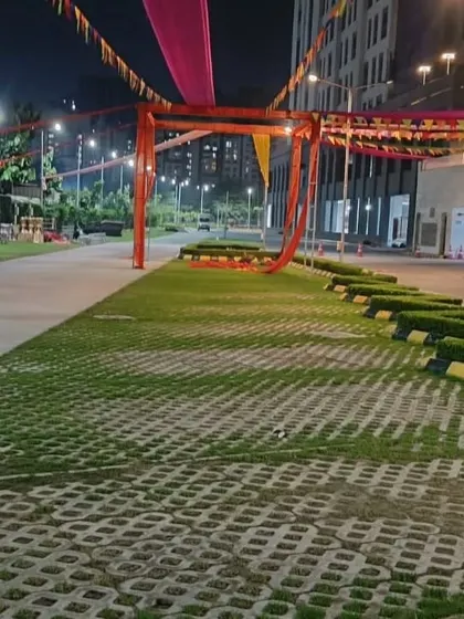 This is a wide shot of an outdoor entrance structure being set up at dusk. The frame is ready for final lighting and shows the scale of the decoration in a large open ground.