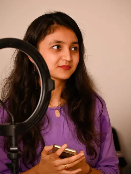 A performer framed by her ring light. This shot uses the artist's own equipment as a compositional element, creating a modern and authentic portrait.