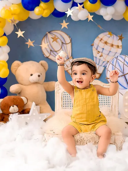 A happy little boy celebrating his first birthday. The excitement in his eyes is perfectly captured in this fun, sky-themed setup.