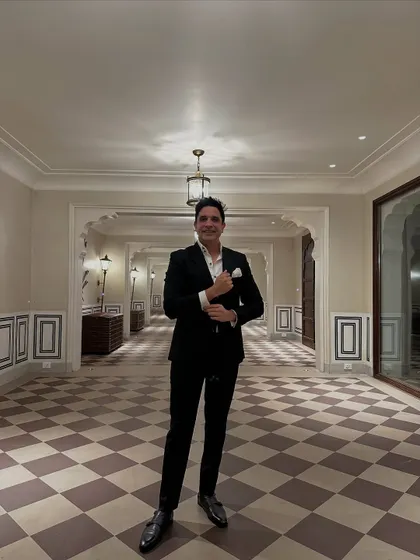 Dressed in a sharp black suit in a classic checkered hallway in Jaipur. This look is perfect for an elegant evening reception or cocktail party.