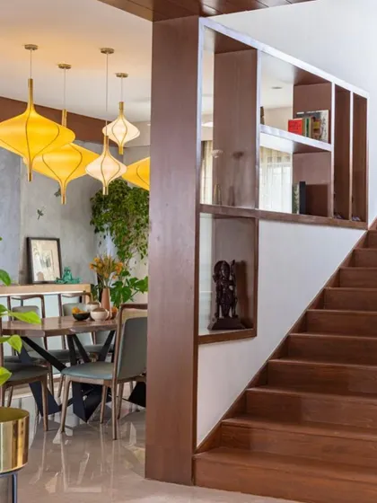 The dining area is visible from the staircase, which features built-in shelving for display and storage. This integration of furniture and architecture is a key part of how we maximize functionality in our designs.