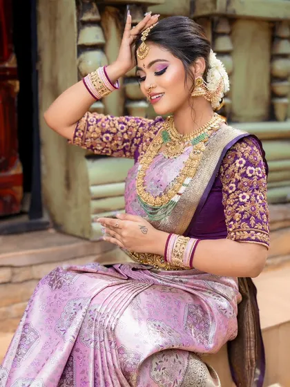 A close-up of the beautiful lavender and pink silk saree, showing the intricate embroidery and jewelry.