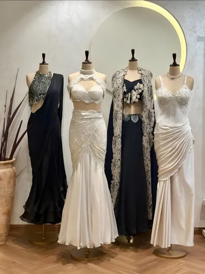 Black and white elegance. Our new collection features a range of stunning outfits in classic monochrome, including draped sarees, lace gowns, and embellished cape sets.