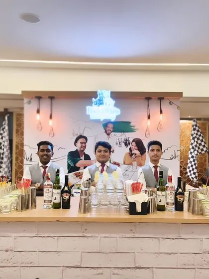 We can create fully themed bars to match your party's concept. This setup, with its white brick finish and racing-themed backdrop, was designed for a private party, complete with pre-batched cocktails ready to go.