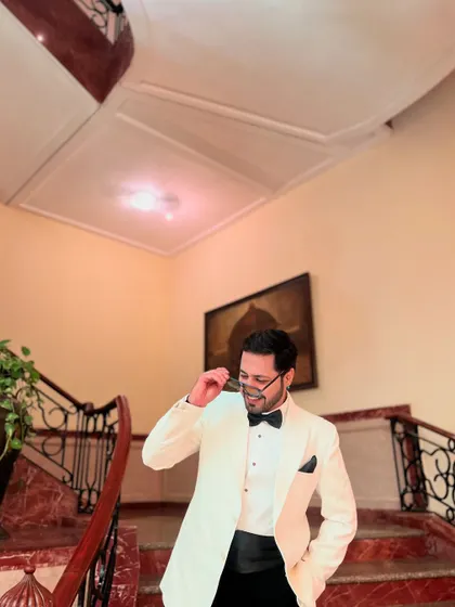 A playful moment, adjusting my glasses while looking dapper in a white tuxedo.
