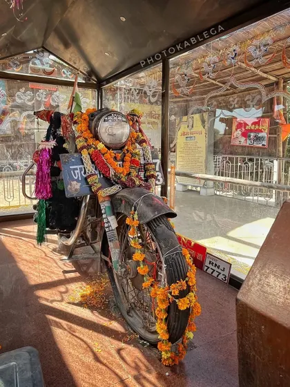 The famous worshipped Royal Enfield motorcycle at Om Banna Temple in Rajasthan, adorned with garlands and offerings from devotees.
