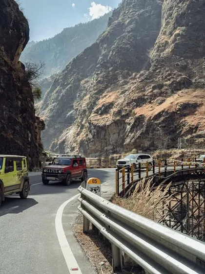 A series of images showing a convoy of 4x4 SUVs navigating the winding, mountainous roads of Spiti. These shots highlight the challenging yet rewarding nature of the expedition.