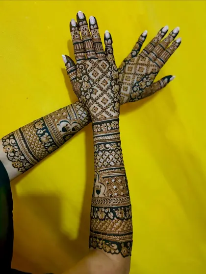 An artistic pose showing the contrast between the front and back designs of this beautiful bridal mehendi.