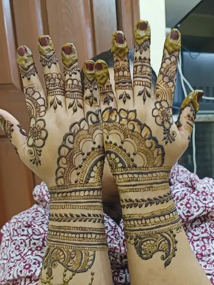 This design features graceful semi-circular patterns on the back of the hand, complemented by small peacock motifs at the wrist. It's a traditional look, perfect for any celebration.