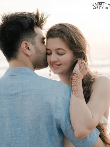 A tender moment from a pre-wedding shoot in Phuket, Thailand. The groom's gentle kiss on the bride's forehead and her happy, serene expression perfectly capture the romance of a beach sunset.