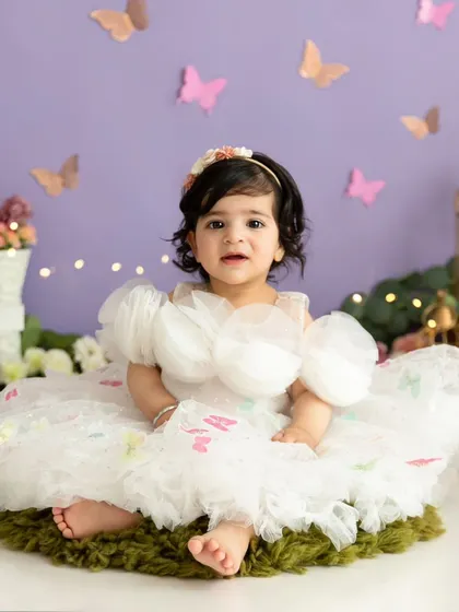 A full-length portrait showing the gorgeous butterfly dress and the enchanting lavender-themed studio setup.