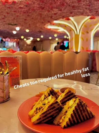Even cheat meals are part of a healthy fat loss journey. This client is enjoying a grilled sandwich at a restaurant, proving that balance is key.