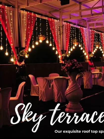 The dining setup at our Sky Terrace during an evening event, with elegant table settings under a canopy of warm lights.