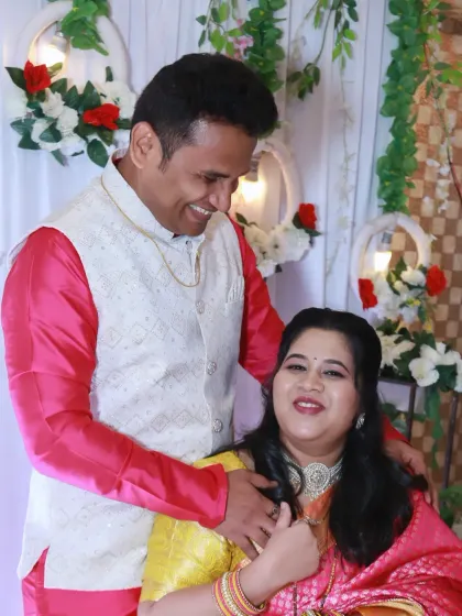 A sweet, candid moment between the new parents, sharing a happy look during the celebration.