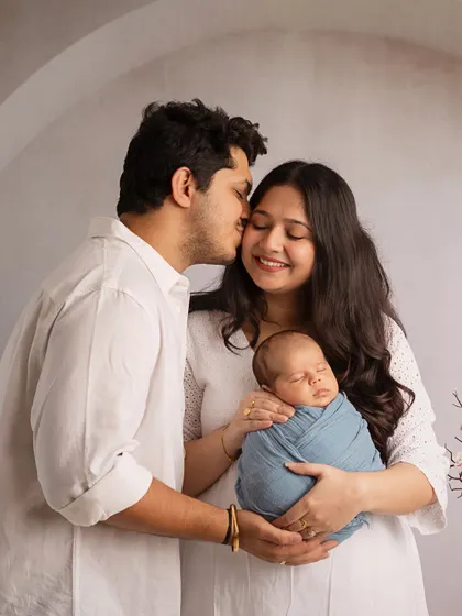 A kiss for mama. This candid moment shows the love and joy that fills the studio during a family newborn session.