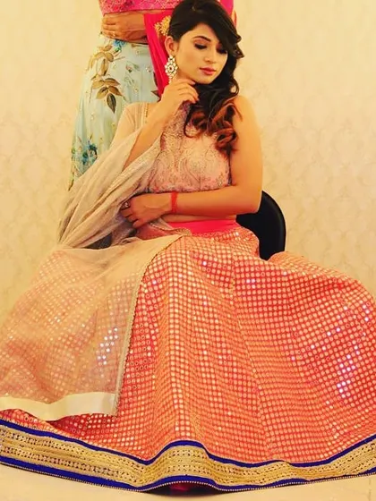 As beautiful as glitter, this peach-colored lehenga with a shimmering pattern is designed to catch the light. Paired with a delicate embroidered blouse, it’s a fantastic choice for an evening of dance and celebration.