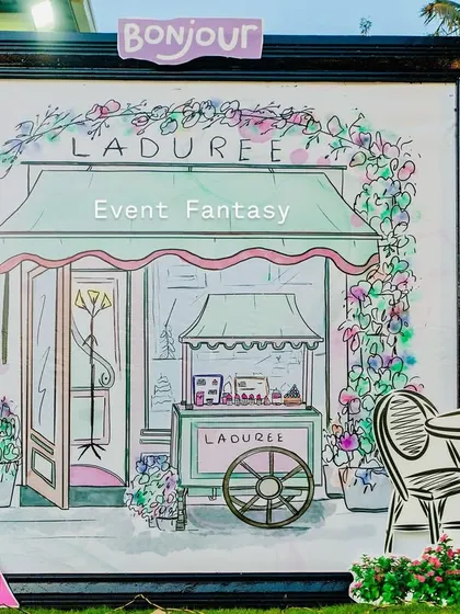 A charming prop featuring an illustration of a Ladurée patisserie, adding an authentic Parisian touch.