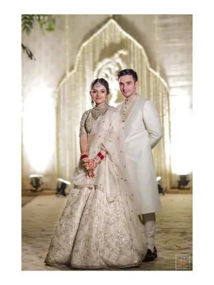 A classic portrait of the couple in their elegant white wedding outfits in Bhubaneswar.