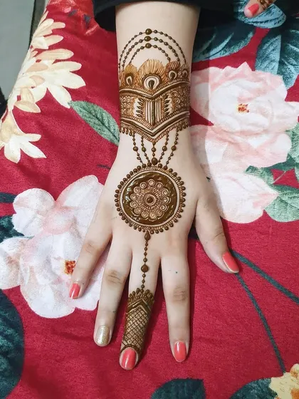 A classic back-of-hand design featuring a central mandala connected to a wrist cuff and a pattern on the finger. This is a timeless and elegant choice.