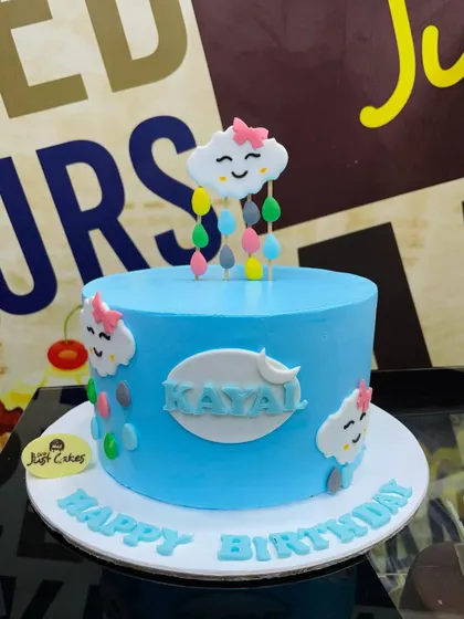 A simple and sweet 1.5kg cake with a cute, smiling cloud topper raining colorful drops.