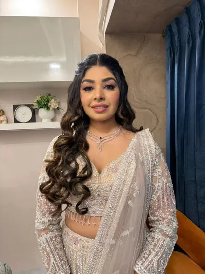 A happy, smiling portrait of the bride. Her makeup is perfectly balanced, with glowing skin and defined eyes that sparkle.