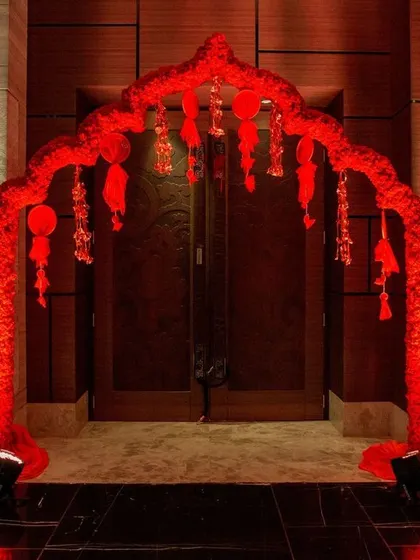 The entrance to the 'Sajjangoth' event, featuring a red floral arch and a colorful welcome sign. This sets the festive and traditional tone right from the start.