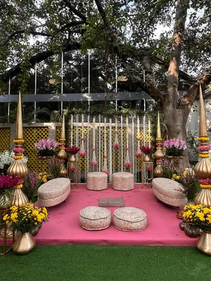 An intimate and elegant mandap, adorned in hues of pink and strings of marigolds, perfect for a daytime ceremony.
